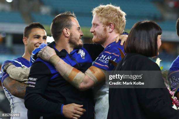 Departing Bulldogs player Josh Reynolds embraces James Graham of the Bulldogs on stage after a presentation to the players and officials leaving the...