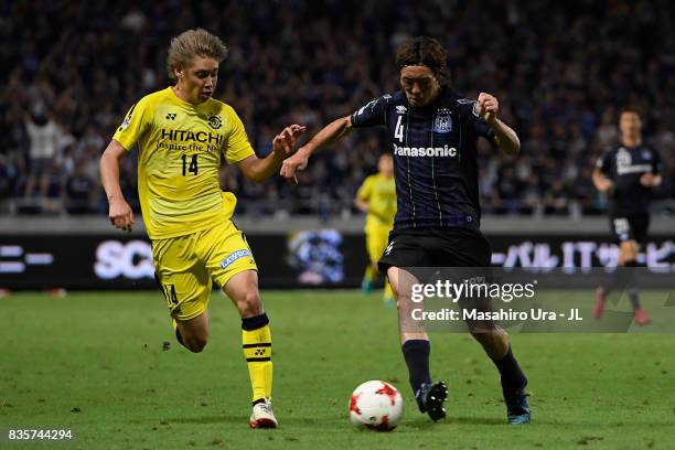 Junya Ito of Kashiwa Reysol and Hiroki Fujiharu of Gamba Osaka compete for the ball during the J.League J1 match between Gamba Osaka and Kashiwa...