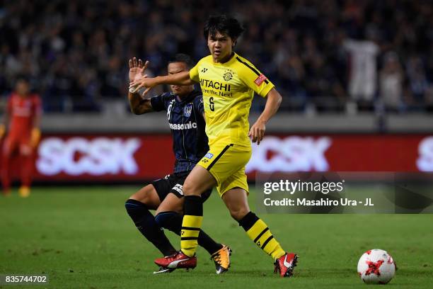 Yusuke Kobayashi of Kashiwa Reysol controls the ball under pressure of Yosuke Ideguchi of Gamba Osaka during the J.League J1 match between Gamba...