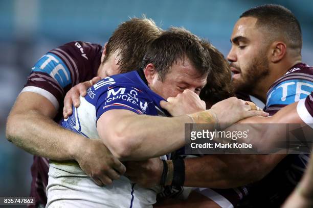 Josh Morris of the Bulldogs is tackled during the round 24 NRL match between the Canterbury Bulldogs and the Manly Sea Eagles at ANZ Stadium on...