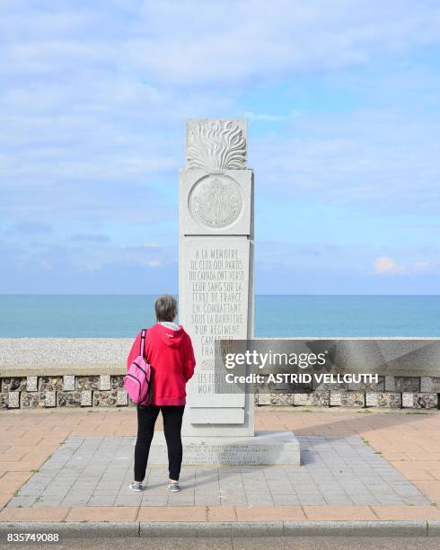 This photo taken on October 9, 2016 in Dieppe shows a woman standing in front of a memorial dedicated to Canadian soldiers during the WWII allied...
