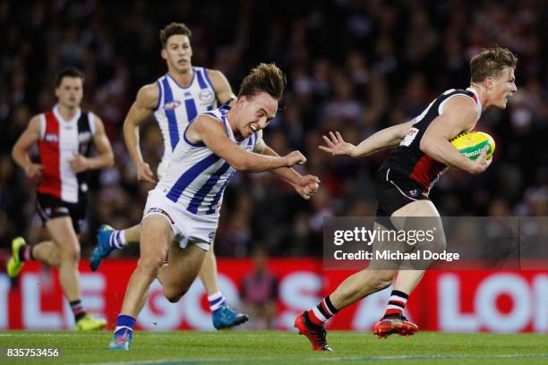 Jack Newnes of the Saints brushes off Ryan Clarke of the Kangaroos during the round 22 AFL match between the St Kilda Saints and the North Melbourne...