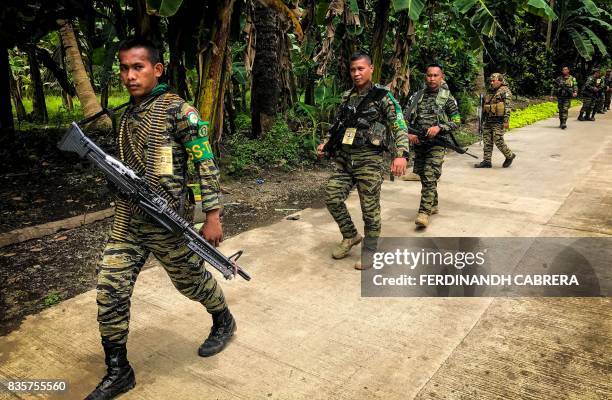 This picture taken on August 19 shows members of Moro Islamic Liberation Front patroling a road in Maguindanao, on the southern Philippine island of...