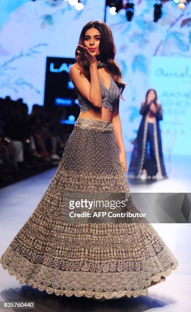 Indian Bollywood actress Nidhhi Agerwal showcases a creation by designer Amoh at the Lakme Fashion Week Winter/Festive 2017 in Mumbai on August 20,...
