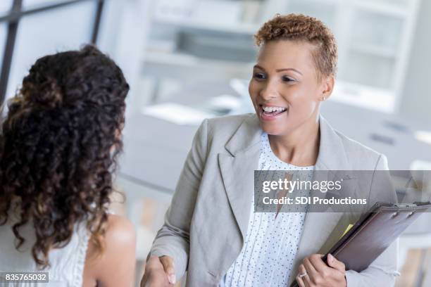 african american businesswoman greets client - admin assistant stock pictures, royalty-free photos & images