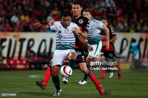 Martinez Osvaldo of Santos Laguna and Damian Mutos of Tijuana compete for the ball during the fifth round match between Tijuana and Santos Laguna as...