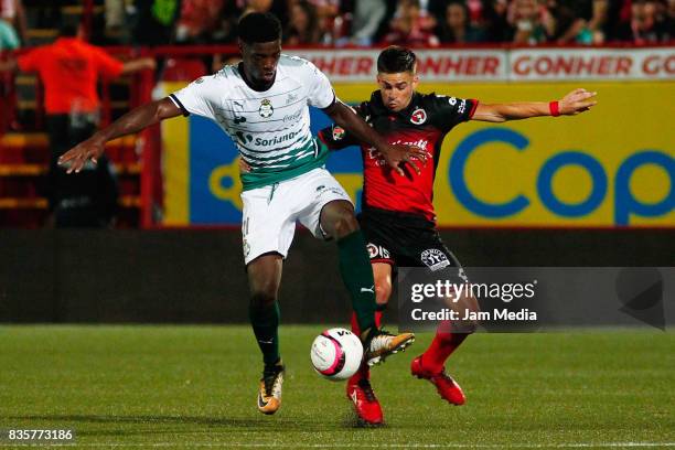 Djaniny Tavares of Santos Laguna and Damian Perez of Tijuana compete for the ball during the fifth round match between Tijuana and Santos Laguna as...