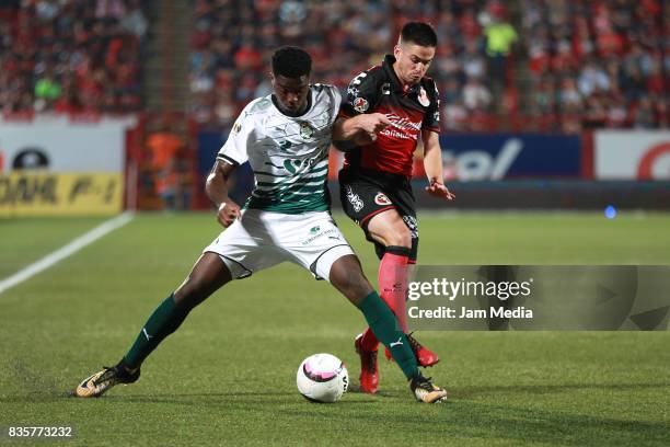 Djaniny Tavares of Santos Laguna and Damian Perez of Tijuana fight for the ball during the fifth round match between Tijuana and Santos Laguna as...