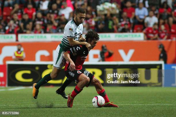 Jonathan Rodriguez of Santos Laguna and Matias Aguirregaray of Tijuana compete for the ball during the fifth round match between Tijuana and Santos...