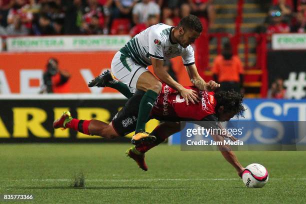 Jonathan Rodriguez of Santos Laguna and Matias Aguirregaray of Tijuana compete for the ball during the fifth round match between Tijuana and Santos...