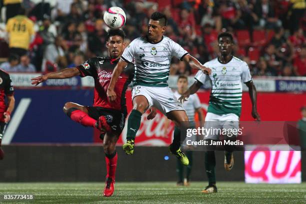 Juan Valenzuela of Tijuana and Osvaldo Martinez of Santos Laguna compete for the ball during the fifth round match between Tijuana and Santos Laguna...
