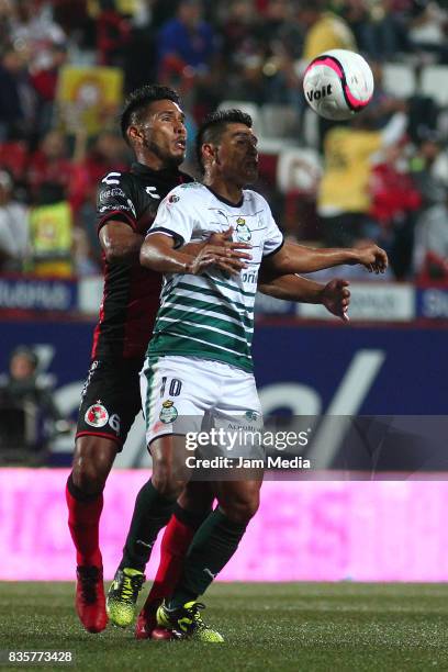 Juan Valenzuela of Tijuana and Osvaldo Martinez of Santos compete for the ball during the fifth round match between Tijuana and Santos Laguna as part...