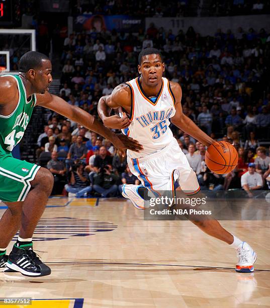 Kevin Durant of the Oklahoma City Thunder dribbles hard toward the basket while being guarded by Kendrick Perkins of the Boston Celtics at the Ford...