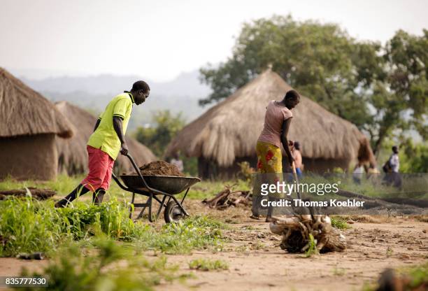 Two young men farm a field at the Rhino Refugee Camp Settlement in the north of Uganda. The area is home to about 90,000 refugees from South Sudan on...