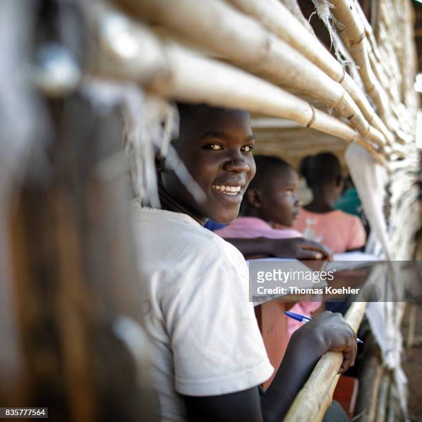 An African boy looks out of a window during the lesson. School at the Rhino Refugee Camp Settlement in northern Uganda. Here, children of local...