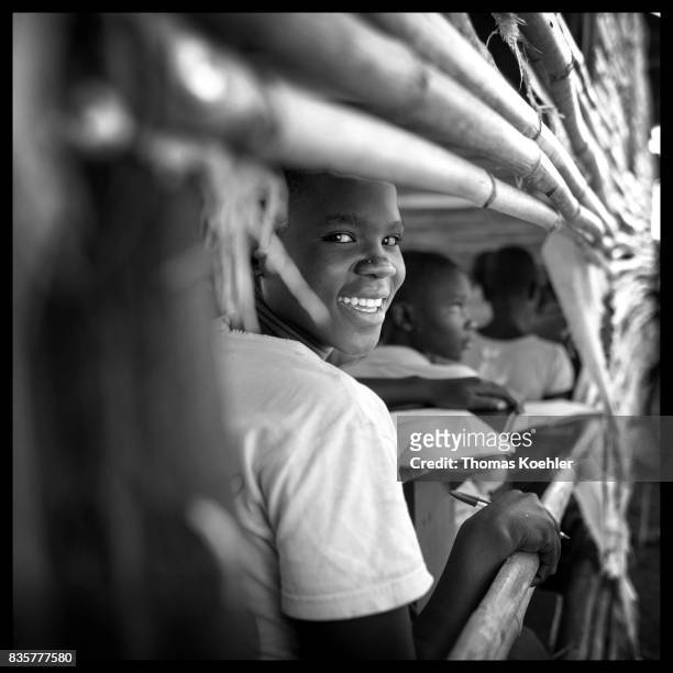 An African boy looks out of a window during the lesson. School at the Rhino Refugee Camp Settlement in northern Uganda. Here, children of local...