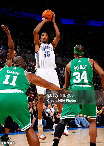 Kevin Durant of the Oklahoma City Thunder shoots a jump shot against a trio of defenders, Leon Powe, Glen Davis, and Paul Pierce, of the Boston...