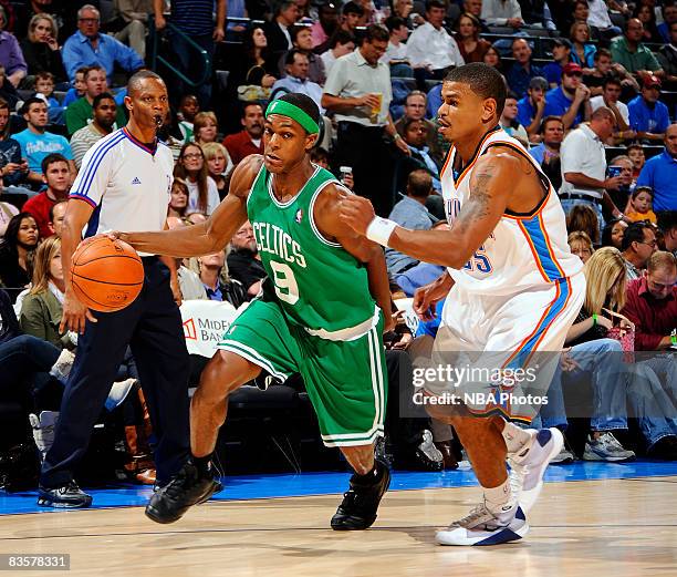 Rajon Rondo of the Boston Celtics dribbles toward the basket while being guarded by Earl Watson of the Oklahoma City Thunder at the Ford Center on...