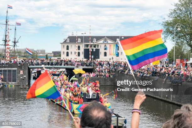 rainbow flag in gay pride parade, amsterdam, netherlands - gay pride parade float stock pictures, royalty-free photos & images