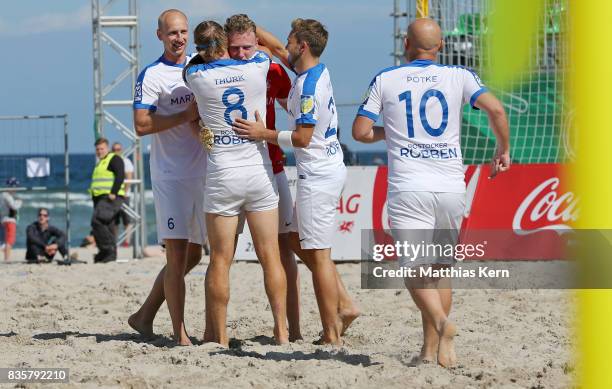 Goalkeeper Robin Schroeder of Rostock jubilates with team mates after scoring a goal during the half final match between Hertha BSC and Rostocker...