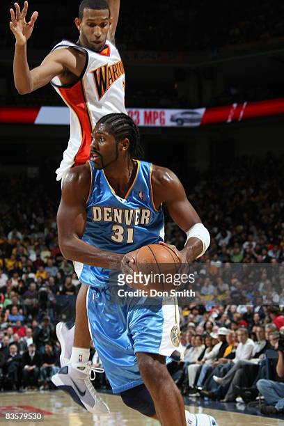 Nene Hilario of the Denver Nuggets makes a pump fake against Brandan Wright of the Golden State Warriors on November 5, 2008 at Oracle Arena in...
