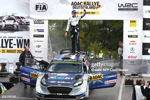 Ott Tanak of Estonia and his co- driver Martin Jarveoja of Estonia celebrate after they finish at the first place in front of Andreas Mikkelsen and...