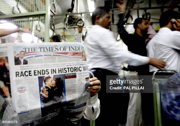 An Indian commuter reads a newspaper carrying US president-elect Barack Obama's win in headlines as he travels in a local train in Mumbai on November...
