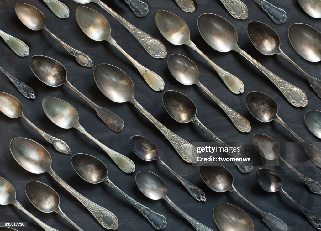 Old vintage metal spoons on black background.