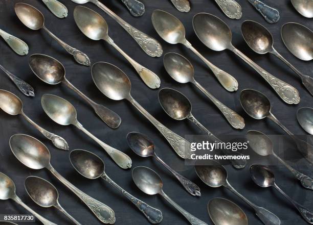 Old vintage metal spoons on black background.