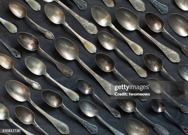 old vintage metal spoons on black background. - colher talheres imagens e fotografias de stock