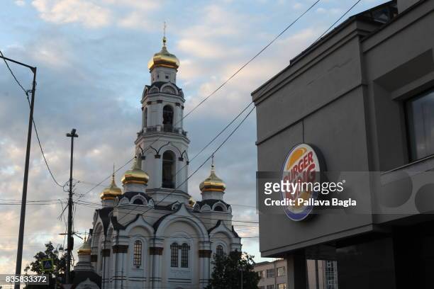 The Great Zlatoust church or Maximilian church stands as a backdrop against 'Burger King' logo on June 25, 2017 in Yekaterinburg, Russia. Situated in...