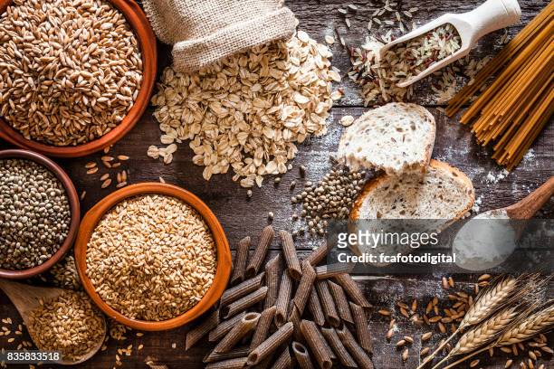 wholegrain food still life shot on rustic wooden table - food staple stock pictures, royalty-free photos & images