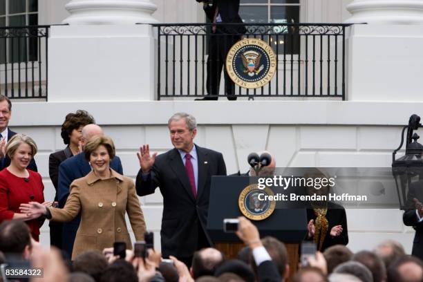 President George W. Bush, joined by his wife Larua Bush, waves before making remarks on the transition to a new Obama administration at the White...