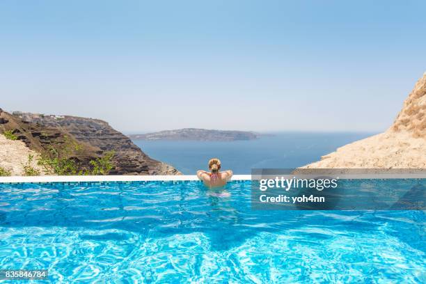 frau in einem infinity-pool im resort spa - griechenland landschaft stock-fotos und bilder