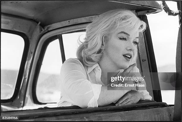 American actress Marilyn Monroe leans over the back of the front seat of a car on the set of 'The Misfits,' directed by John Huston, Nevada, 1960.