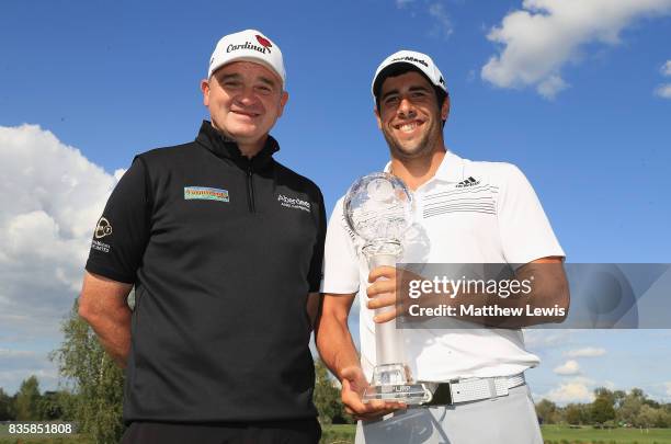 Adrian Otaegui of Spain receives the trophy from Paul Lawrie of Scotland following his victory over Marcel Siem of Germany during the final...