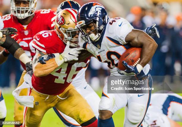 Denver Broncos running back Juwan Thompson fights off San Francisco 49ers tight end Cole Hikutini as he races towards the end zone during the...