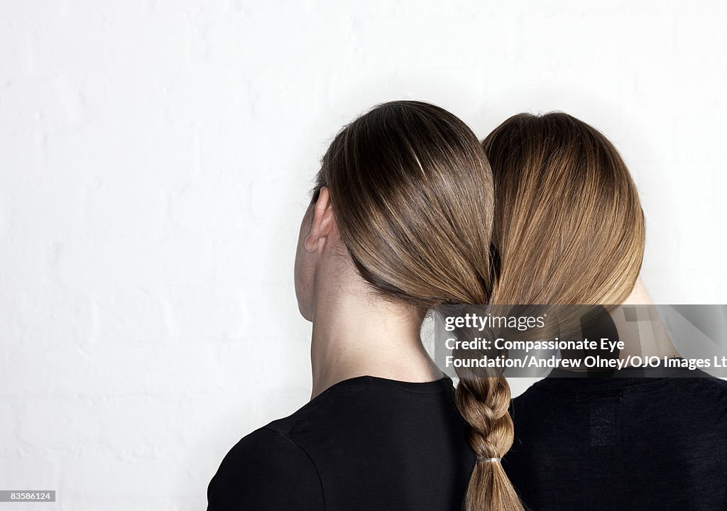Two women tied together by hair plait