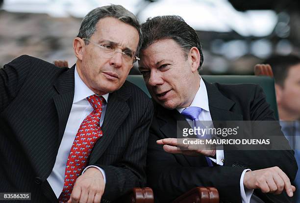 Colombian Defense Minister Juan Manuel Santos speaks with Colombian President Alvaro Uribe during the Colombian army Commander Gen. Oscar Gonzalez...