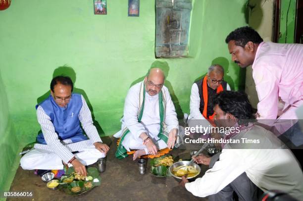 President Amit Shah along with Chief Minister Shivraj Singh Chouhan having lunch at the residence of tribal Kamal Singh Uike, who belongs to Gond...