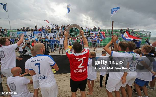 The players of Rostock celebrate with the trophy and his supporters after winning the final match between Rostocker Robben and Ibbenbuerener BSC on...