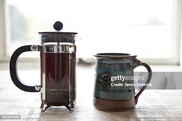 coffee plunger and mug on table - coffee plunger stock-fotos und bilder