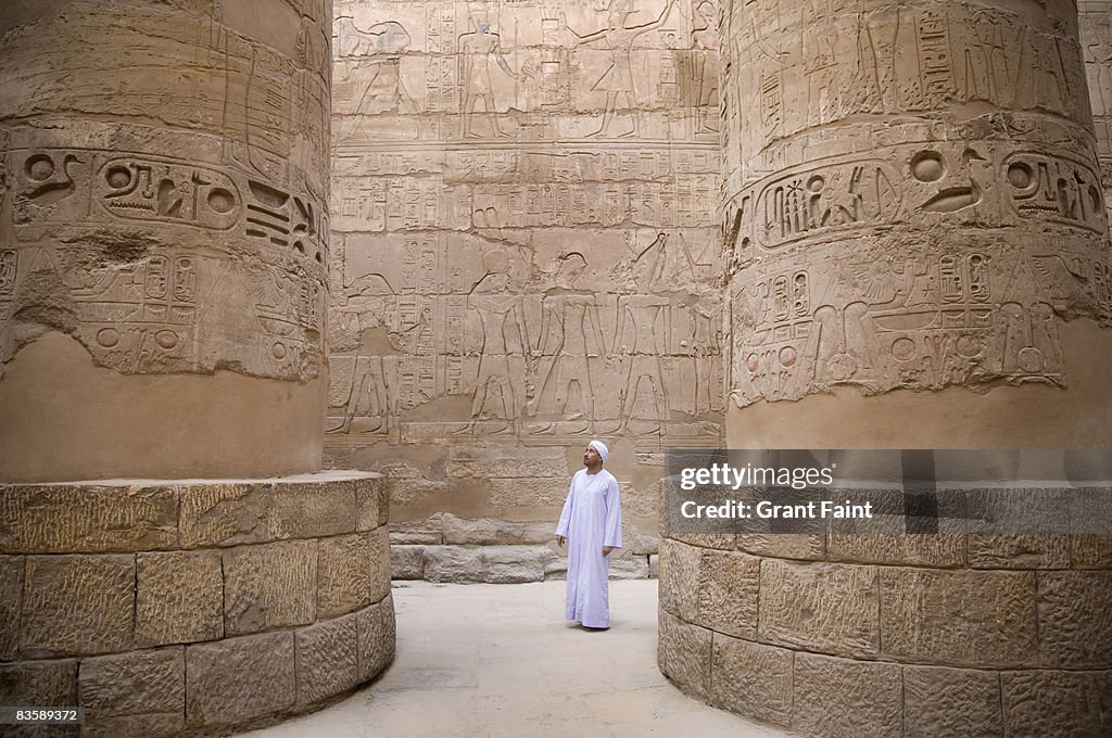 Egyptian man standing in Karnak temple columns