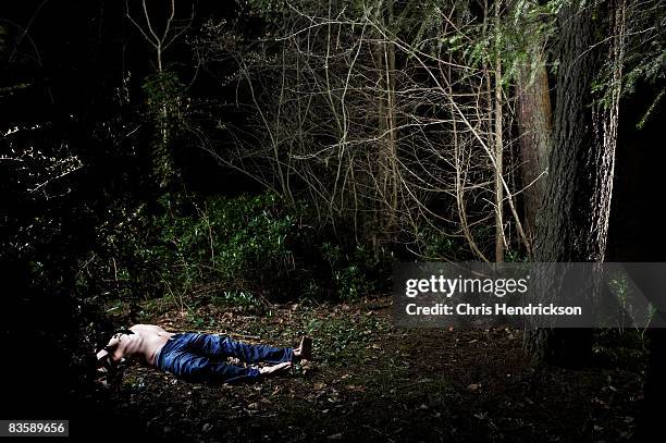 body of a man lying in bushes. - semi dress stock pictures, royalty-free photos & images