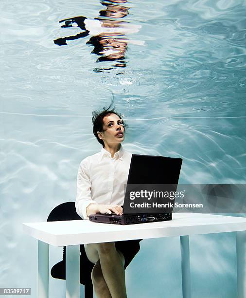 woman working on her laptop under water - out of context stock pictures, royalty-free photos & images