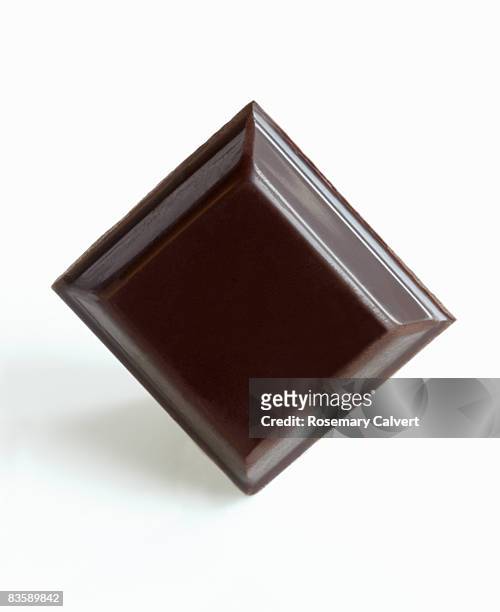 square of dark chocolate. - dark chocolate on white stock pictures, royalty-free photos & images