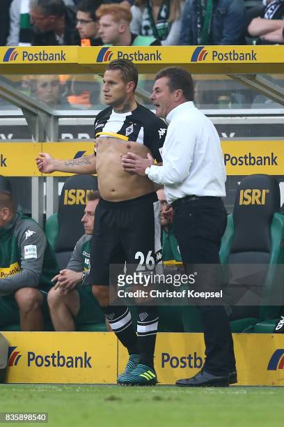 Dieter Hecking, coach of Moenchengladbach, speaks with substitute Raul Bobadilla of Moenchengladbach during the Bundesliga match between Borussia...