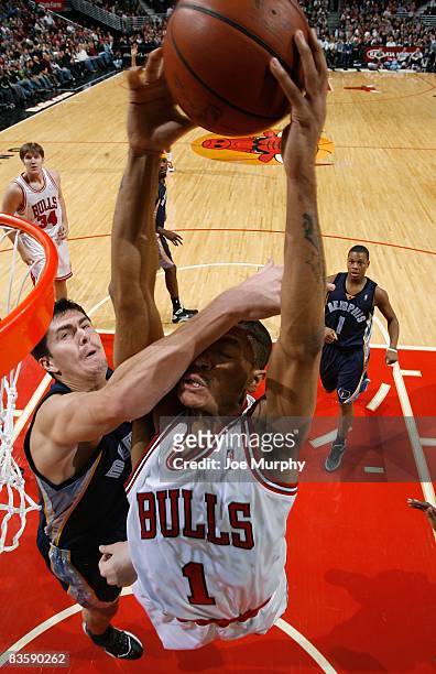 Derrick Rose of the Chicago Bulls draws contact going for the dunk against Darko Milicic of the Memphis Grizzlies during the game at the United...