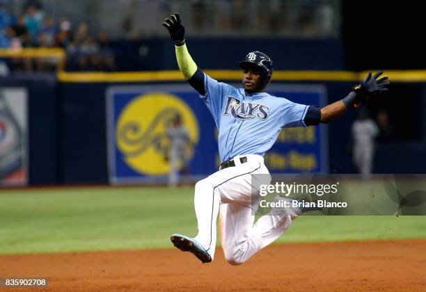 Adeiny Hechavarria of the Tampa Bay Rays leaps to slide into third base after hitting a triple off of pitcher Yovani Gallardo of the Seattle Mariners...