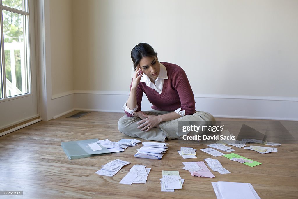 Woman looking at bills and receipts on floor
